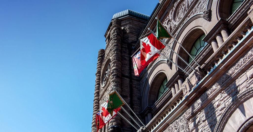 Flags hanging outside the Ontario Legislature building.