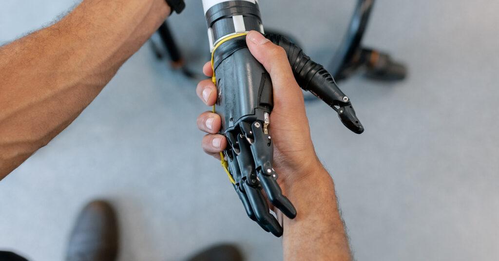 A human hand shaking a robotic hand.